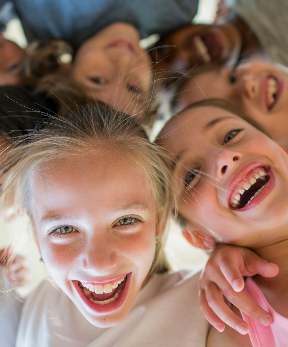 Kindergesichter im Kreis von unten